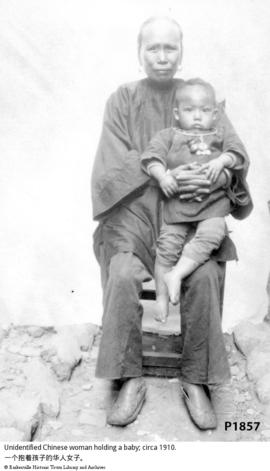 Unidentified Chinese woman holding a baby; circa 1910.