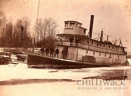Side view of river steamer S.S. Gladys locked in river ice