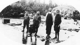 Four Chinese Children Standing in a Shallow Creek with a Coal Slack Pile in the Background